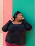 Fototapeta  - Mujer con sobrepeso disfrutando de música en fondo bicolor
