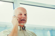 Elderly man focused during outdoor phone conversation
