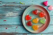 Set of sweets in the shape of heart on plate on wooden background.