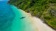 Sandy beach with beautiful sea water and long-tail boats on the pristine white beach of Bat Island in the Andaman Sea of Ranong Province, southern Thailand, Asia