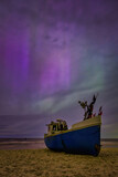 Fototapeta Uliczki - Aurora over the Baltic Sea on the beach in Katy Rybackie with fishing boat in Poland.