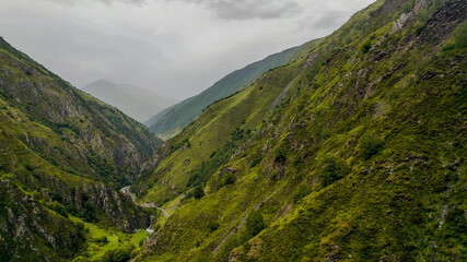 Panoramic view of misty green mountains with an ancient solitary tower, ideal for articles on hiking, nature conservation, and Earth Day backgrounds