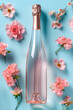 A rosé champagne bottle set amidst pink blossoms on a blue background, capturing the essence of spring.
