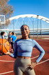 Portrait of young African American woman on basketball court looking at camera and holding ball in her hands.