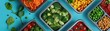 A close-up top view of lunchboxes with low-carb meals, the focus on colorful vegetables and lean proteins, set against a muted, contemporary teal table, providing a wide, panoramic