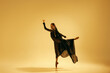 © master1305 - Beautiful woman, ballet dancer in elegant black costume and head golden accessories dancing against sand color background. Concept of art, classical dance, beauty and fashion, aesthetics