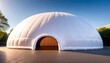 © Sema - A white inflatable dome structure stands in the center of a parking lot, surrounded by empty spaces and cars