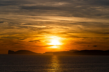 Wall Mural - Sun goes down behind Capo Caccia in the north of Sardinia, Italy