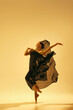 © master1305 - Full-length of beautiful female ballet dancer making creative performance, dancing in flowing black costume against sand color background. Concept of art, classical dance, beauty, fashion, aesthetics