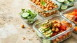 Meal prepping concept featuring containers filled with chickpeas, avocado, and fresh vegetables