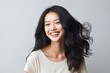 © MediaRaw - A woman with long hair is smiling and wearing a white shirt