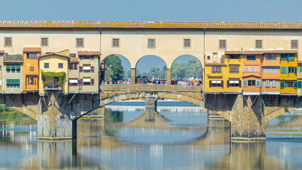 Wall Mural - The Ponte Vecchio on a sunny day timelapse, a medieval stone segmental arch bridge over the Arno River, in Florence, Italy