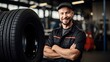 © inthasone - Smiling Car mechanic with car tire. Repair or maintenance auto service.