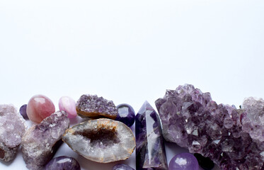 Wall Mural - Beautiful druses of natural purple mineral amethyst on a white background. Healing chakra crystals. Copy space.