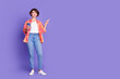 © deagreez - Full size photo of pretty young girl smart phone point finger empty space wear shirt isolated on violet color background