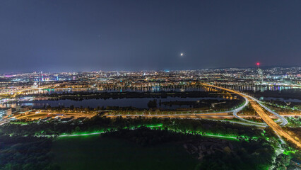 Wall Mural - Aerial panoramic view over Vienna city with skyscrapers, historic buildings and a riverside promenade night timelapse in Austria.