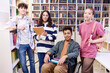 Front view portrait of inclusive group of teenage students looking at camera posing in school library and holding books