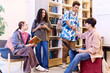 © Seventyfour - Full length portrait of multiethnic group of teenagers relaxing and chatting during break in modern school library