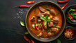 Thai red curry with lamb in a bowl on a black background