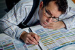 Businessman attentively reading a financial report or reviewing a detailed balance sheet, using analytical skills to interpret complex financial information