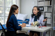 © apichat - A woman is sitting at a desk with a doctor