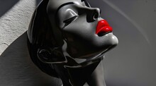 A Black And Red Sculpture Of A Woman's Face.