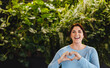 © Jacob Lund - Office of sustainability: Business woman doing a heart gesture in an environmentally friendly business space