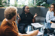 © Jacob Lund - Black business woman talking to her colleagues during a team meeting in an office