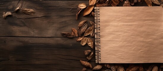 Wall Mural - A notebook with a wooden pattern and dried leaves serves as a captivating background for a presentation offering ample copy space for images