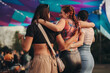 © Jacob Lund - Three female friends embracing as they come together for a blissful summer festival experience