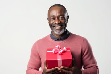 Sticker - Portrait of a smiling afro-american man in his 40s holding a gift isolated in white background