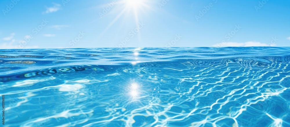 A serene outdoor swimming pool with crystal clear blue water reflects ...