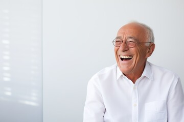 Wall Mural - Portrait of a smiling man in his 70s laughing isolated on modern minimalist interior