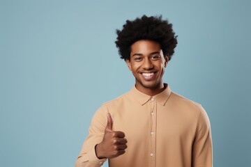 Poster - Portrait of a blissful afro-american man in his 20s showing a thumb up over modern minimalist interior