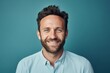 © Markus Schröder - Portrait of a blissful man in his 30s smiling at the camera isolated on pastel blue background