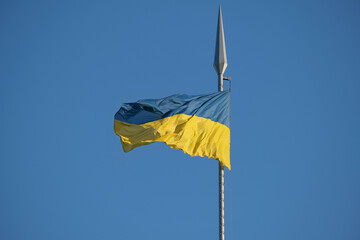 Ukrainian flag against of a serene blue sky. Symbol of the freedom of Ukrainian nation. Flag consists of two horizontal bands of equal width, with top band being sky blue and bottom band being yellow.