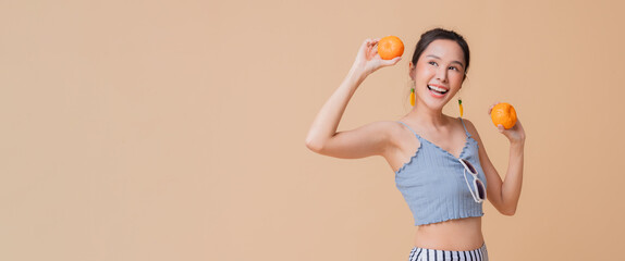 summer freshness asian cheerful swimwear woman wear sun glasses hand hold fresh orange fruit smiling happiness summertime advertisment studio photoshoot cute and curious friendly on color screen