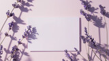 Fototapeta  - Cartão de papel branco em branco deitado nas sombras ao lado de algumas flores de lavanda em fundo rosa pálido. Vista superior, espaço de cópia