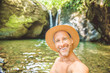 © Louis-Paul Photo - Self-portrait of happy standing against waterfall in green exotic woods.