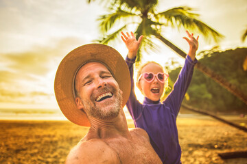 Wall Mural - nice man having great time on beach with his daughter