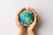 © Nuttakarn - Hands Holding Earth Globe Against Sky Background