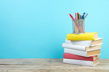 Canvas Print - Books stacking. Books on wooden table and blue background. Back to school. Copy space for ad text.