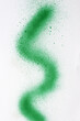 wavy line of green spray paint on white paper background