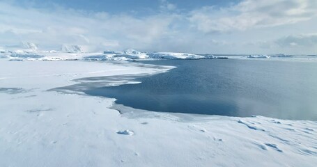 Wall Mural - Fly above frozen panorama of Antarctic winter landscape. Aerial drone footage ice ocean and snow-covered mountains in background. Expeditions and adventures in Antarctica. Discover South Pole beauty