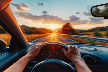 Wall Mural - Close-up of drivers hands on steering wheel on summer road trip at sunset in vacation