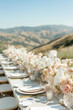 A beautifully decorated outdoor table with bouquets of roses, candles, luxury tableware and cutlery.