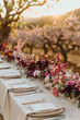 A beautifully decorated outdoor table with bouquets of various flowers, cendles, luxury tableware and cutlery