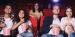 © Pixel-Shot - Friends with popcorn watching movie in cinema