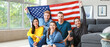 © Pixel-Shot - Happy friends with USA flag at home. Independence Day celebration