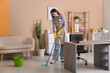 Young woman mopping floor in living room